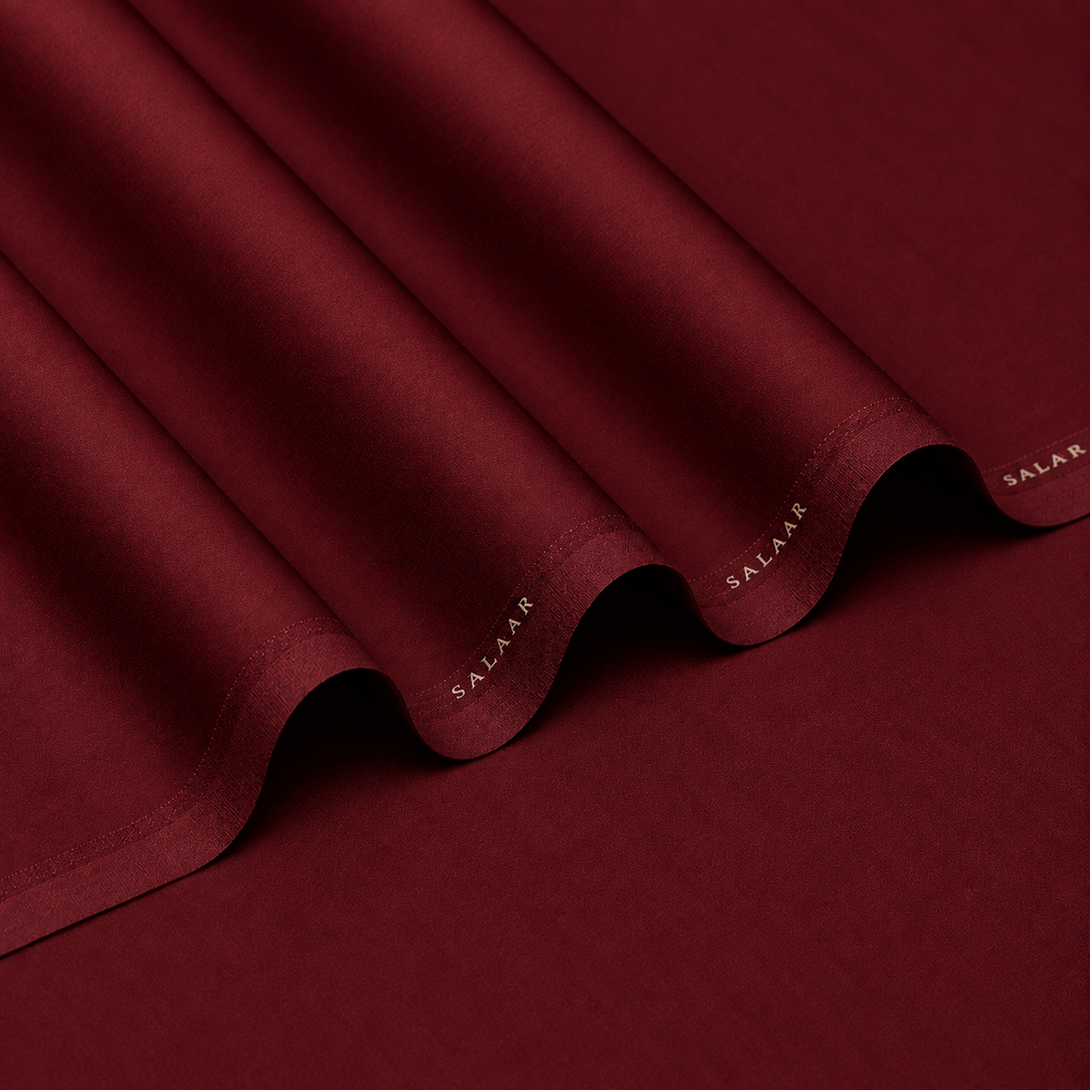 SALAAR Burgundy Royale Summer Blend fabric with flowing folds and SALAAR woven border