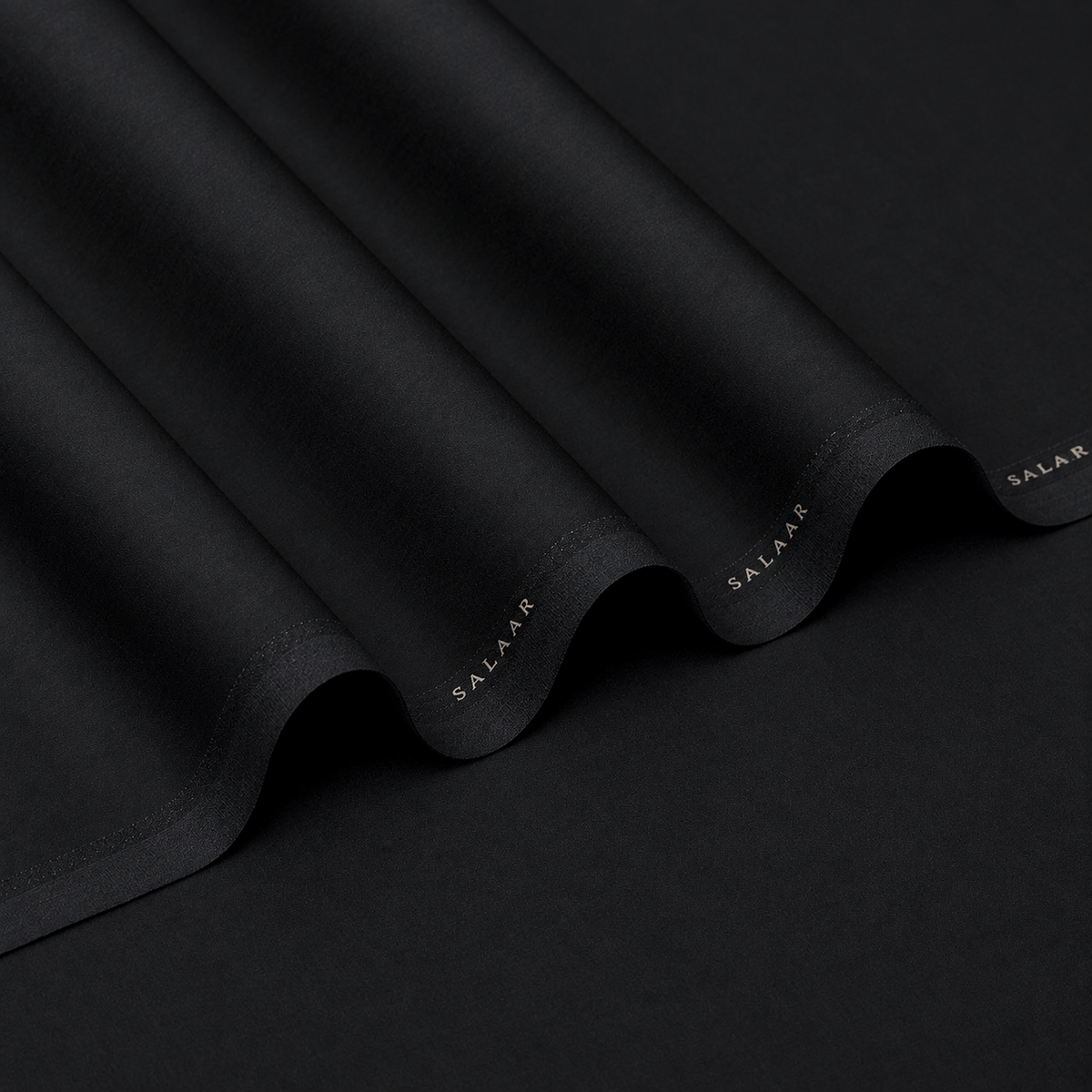 SALAAR Onyx Noir Summer Blend black fabric with flowing folds and SALAAR woven border